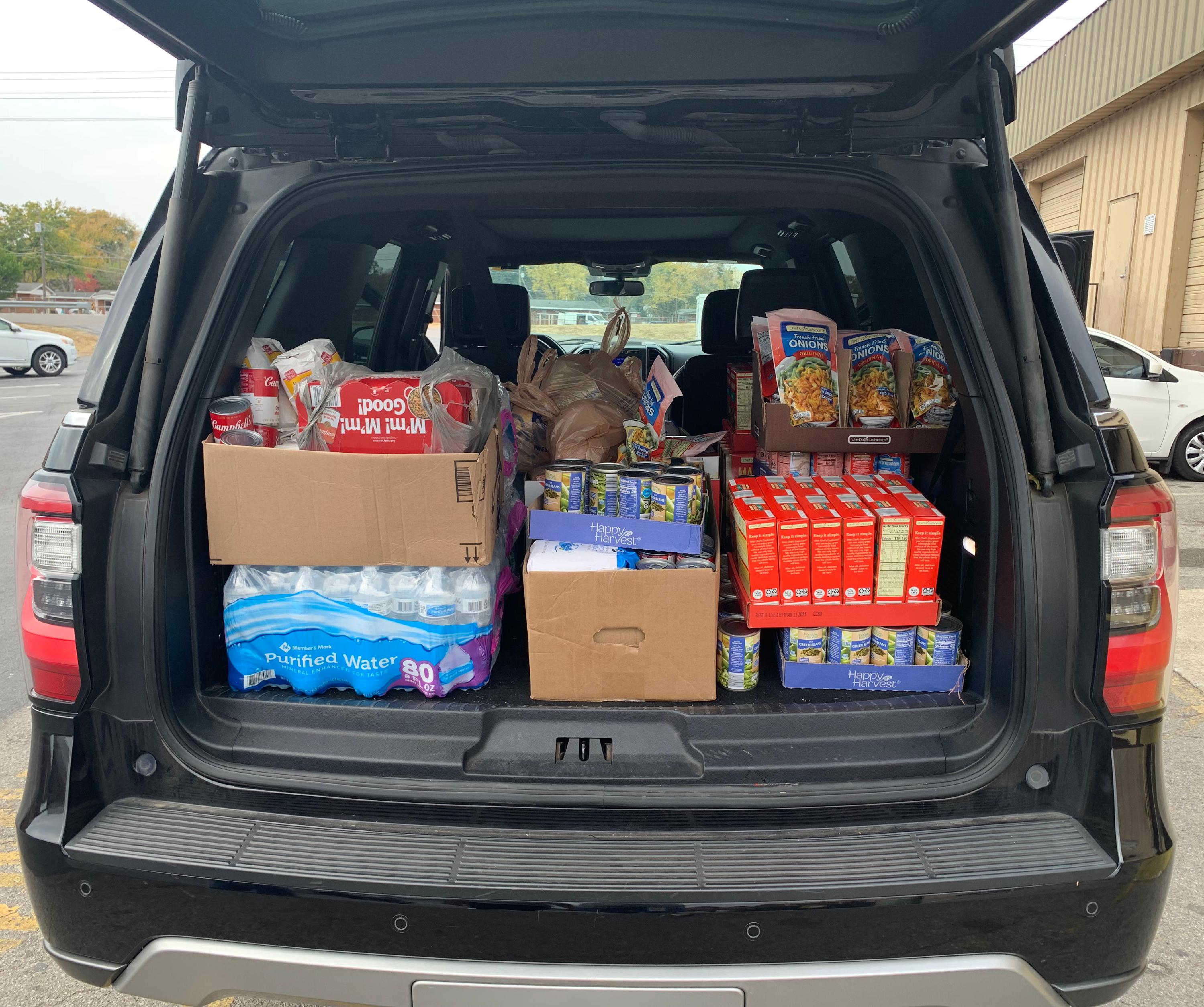 The back of an SUV filled with donated food. 